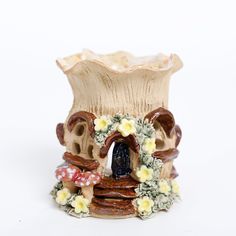 a ceramic vase with flowers around it on a white background