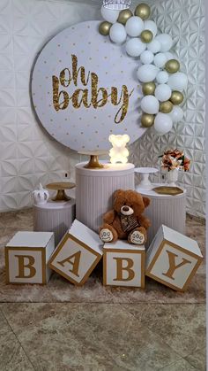 a teddy bear sitting on top of blocks in front of a sign that says baby