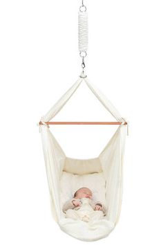 a baby is laying in a hammock hanging from a chain on a white background