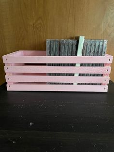 a pink wooden crate sitting on top of a table