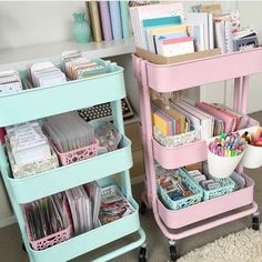 two pink and blue rolling carts filled with crafting supplies in a home office area