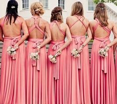 a group of women in pink dresses standing next to each other with their backs turned