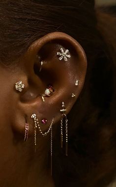 a close up of a person's ear with different types of piercings on it