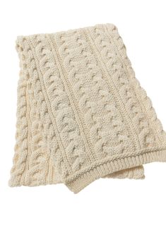 two white knitted blankets sitting on top of each other