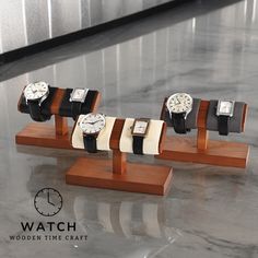 five watches on wooden stand with white and black straps