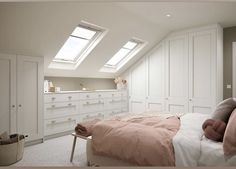 a bedroom with two skylights above the bed and dressers in front of it