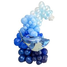 a shark balloon floating on top of blue and white balloons