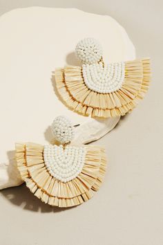 Add a playful touch to your outfit with these Ivory Raffia Fan Drop Earrings. These 1.75 inch earrings feature a fun raffia fan style made of white seed beads, sure to make a statement. With a stud backing, they are easy and comfortable to wear. 1.75 in Neutral, adds fun to any outfit! Lightweight White seed beads with raffia fan style Stud backing Ships FAST and FREE with all orders over $65! Raffia Earrings Diy, Handmade White Beaded Earrings For Vacation, White Beaded Earrings For Summer Vacation, White Woven Beach Jewelry, Handmade White Tassel Earrings For Beach, Tawny Autumn, Raffia Earrings, Beading Earrings, Fan Style