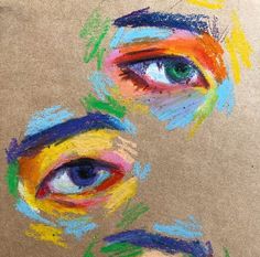 two colored eyes are shown in the middle of a drawing with crayons on it