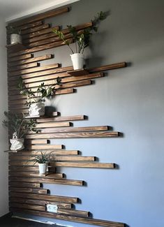 the wall is made out of wooden planks and has plants on it, along with two potted plants