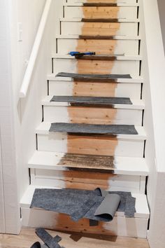 a set of stairs that have been painted white and has carpet on the floor next to it