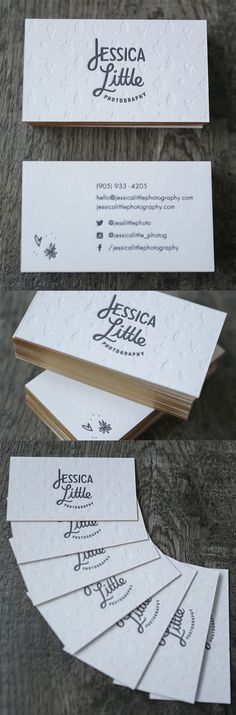 some business cards are laying on top of each other, with the name and logo