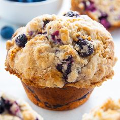 muffins with blueberries and crumbs sitting on top of each other