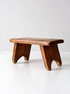 a wooden bench sitting on top of a white table