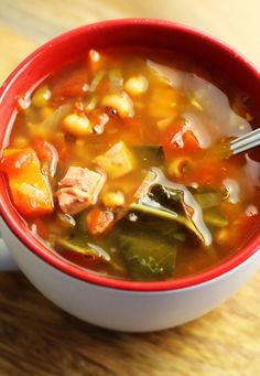 a red bowl filled with soup on top of a wooden table