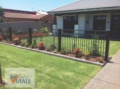 a house with a fence and flowers in the front yard