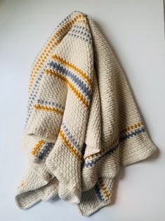 a white blanket with yellow and blue stripes