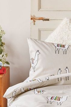 an unmade bed with llamas on it