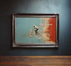 a man riding a bike in front of a painting hanging on the wall next to a wooden table