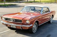 an orange and white mustang parked in a parking lot