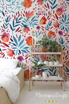 a bedroom with colorful wallpaper and plants on the shelf in front of the bed