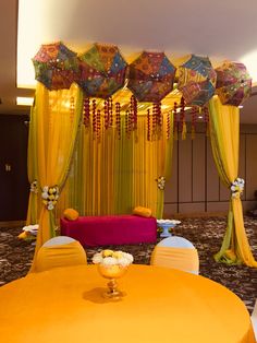 a room decorated with yellow drapes and colorful decorations