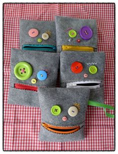 four gray felt bags with buttons on them