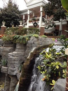 a waterfall in front of a large house