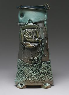 a green vase with a rose on it