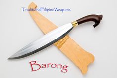 a knife on top of a wooden board with the word barong written below it