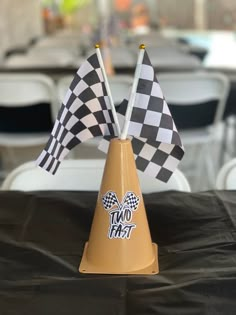 two flags sticking out of a cone sitting on top of a black tablecloth covered table