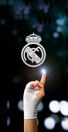 a hand holding up a finger with the real madrid logo on it