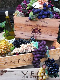 several wooden boxes filled with different types of grapes