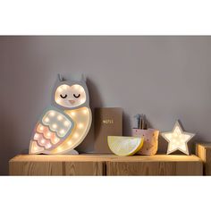 an owl shaped light sitting on top of a wooden shelf next to a box and other items