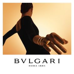 a woman in black dress holding out her hand with the words bvlgari roma