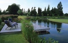 there is a small dock in the middle of the water with two lawn chairs on it