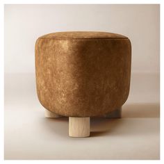 a brown ottoman sitting on top of a wooden stand