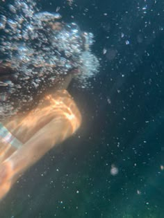 a person swimming under the water with their feet in the air