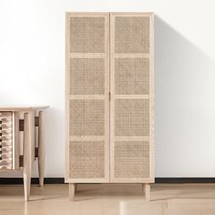 a white cabinet sitting next to a wooden table on top of a hard wood floor