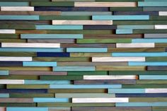 a wall made out of wooden planks with blue, green and brown strips on it