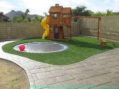 a backyard with artificial grass and a play set