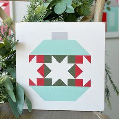 a christmas ornament sitting on top of a table next to a potted plant