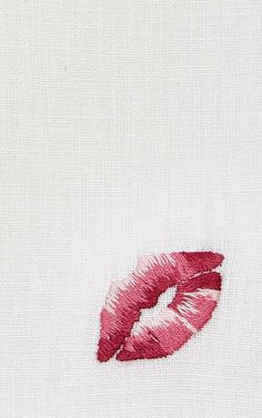 a close up of a red lip on a white shirt