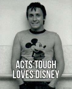 a black and white photo of a man in mickey mouse shirt