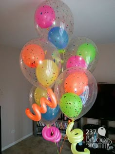 a bunch of balloons that are on top of each other in the middle of a room