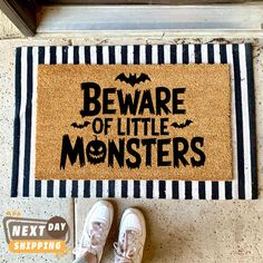 a door mat with the words beware of little monsters on it next to shoes