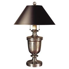 a silver lamp with a black shade on it's side and a white background