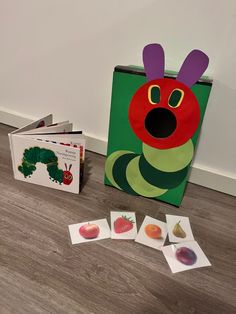 the very hungry caterpillar board book and matching cards are on the floor next to it