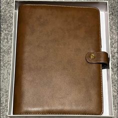 a brown leather notebook in a white box