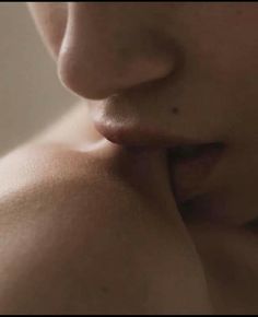 a close up of a woman's face with her hand on her lip and nose